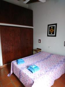 ein Schlafzimmer mit einem Bett mit blauen Handtüchern darauf in der Unterkunft Casa familiar en Posadas in Posadas