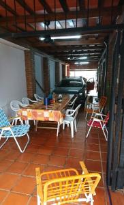 eine Terrasse mit Stühlen, einem Tisch und einem Auto in der Unterkunft Casa familiar en Posadas in Posadas