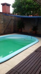 a swimming pool with green water in front of a brick wall at Casa familiar en Posadas in Posadas