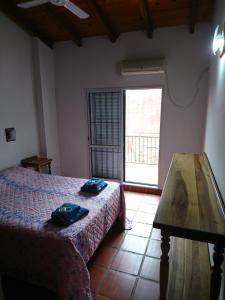 a bedroom with a bed and a table and a window at Casa familiar en Posadas in Posadas +14 photos