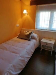 a small bedroom with a bed and a table at El Cerrillo II in San Martín del Pimpollar