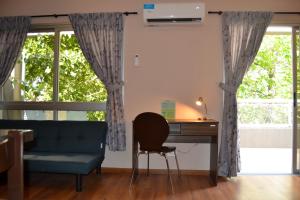 sala de estar con escritorio, silla y sofá en MendoApart Suite en Mendoza