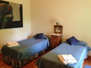 Habitación con 2 camas y una pintura en la pared. en Los Abetos B&B 4 en El Bolsón