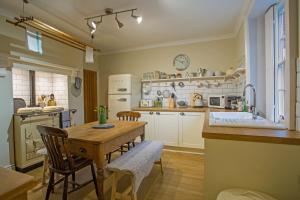 een keuken met een tafel en stoelen en een keuken met een wastafel bij Cosy Country Cottage in City Centre in Gloucester