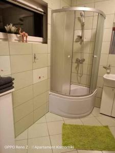 a bathroom with a shower and a green rug at Apartament Komorniki in Komorniki