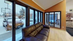 a brown leather couch in a room with windows at Waconia Inn and Suites in Waconia +13 photos
