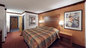 a hotel room with a bed and a picture on the wall at Waconia Inn and Suites in Waconia