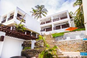 uma vista exterior de uma casa com escadas e um guarda-chuva laranja em Hotel Los Farallones em La Libertad