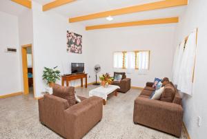 a living room with three couches and a tv at Muri Homeland Villa in Rarotonga