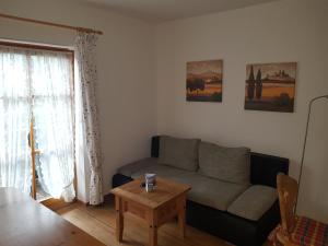 a living room with a couch and a table at Ferienwohnungen am Buchbrunnen in Pfronten