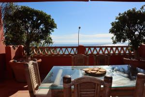 ein Tisch und Stühle auf einem Balkon mit Blick auf das Meer in der Unterkunft Penthouse Luxury Faro Casasol in Torrox Costa