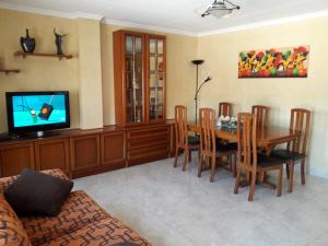 a living room with a dining room table and a television at Kal massis in Pinell de Bray