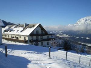 ein Haus auf einem schneebedeckten Berg in der Unterkunft Berggasthof Schwaigerhof in Haus im Ennstal