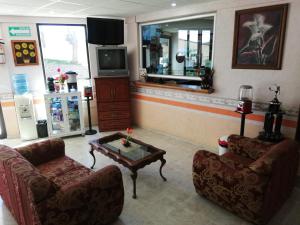 a living room with two chairs and a coffee table at Hotel Villa De Las Flores in Zacatlán