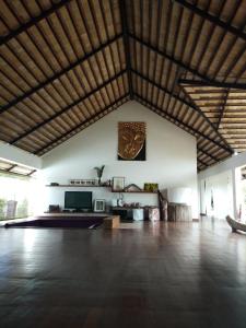 a living room with a wooden floor and a large ceiling at Villa Kalachuchi V.K in Puerto Princesa City