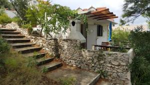 una pared de piedra con escaleras que conducen a una casa en Holiday House Doda, en Povlja