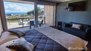 a bedroom with a bed and a view of the ocean at SaldeMar Playa Hermosa in Pichilemu