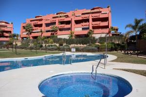 ein Pool mit einem Gebäude im Hintergrund in der Unterkunft Penthouse Luxury Faro Casasol in Torrox Costa
