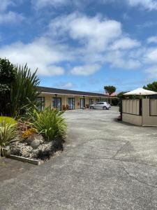 a building with a car parked in a parking lot at Arikilodge in Waikanae