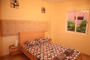 ein Schlafzimmer mit einem Bett und einem Fenster in der Unterkunft Penthouse Luxury Faro Casasol in Torrox Costa + 37 Fotos