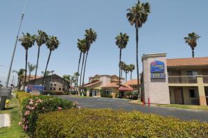 a sign for a gas station on a street with palm trees at Country Inn Ontario in Ontario