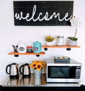 una encimera de cocina con microondas y un cartel que diga bienvenida en Anchor Pointe Inn en Wilmington