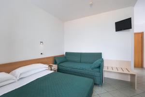 ein Schlafzimmer mit einem Bett und einem blauen Sofa in der Unterkunft Hotel Haiti in San Benedetto del Tronto
