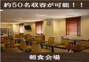 un restaurante con mesas y sillas y un reloj en la pared en Kuretake-Inn Yaizuekimae en Yaizu