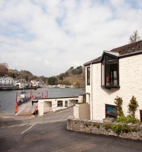 a building next to a dock with a body of water at Tabs Cottage in Fowey