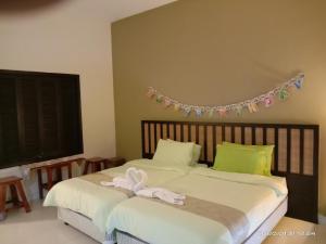 um quarto com duas camas com um laço em Izz room studio Gold Coast Morib Resort em Banting