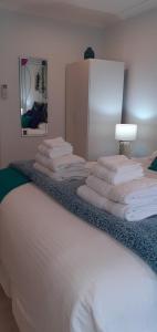 a bed with a bunch of folded towels on it at Thistle B&B in Napier