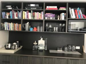 a book shelf with books on it with a counter at Villa @23 in Wanaka