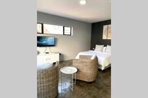 a bedroom with a bed and a desk with a television at Lower Point Surf Studio 2 in Jeffreys Bay
