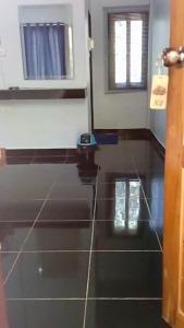 a bathroom with a black tiled floor with a window at Nong Or Blue House Resort in Sukhothai