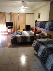 a bedroom with two beds and a living room at Hotel Central park in Santa Clara del Mar