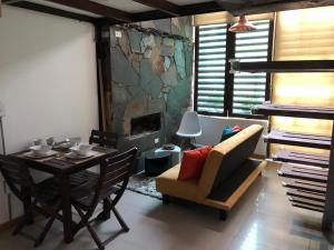 a dining room with a table and chairs and a fireplace at ESTAR AQUI Bogotá in Bogotá