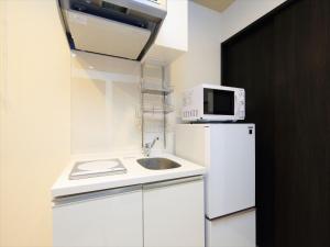 uma cozinha com um frigorífico branco e um micro-ondas em COTO Tokyo Shibuya 8 em Tóquio