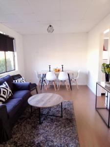 a living room with a couch and a table at The Husky House or The Husky Studio Suite stayinjervisbay com in Huskisson