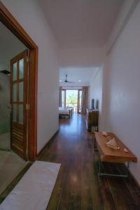 an empty living room with a table and a door at Cardamon Hotel Nilaveli in Nilaveli