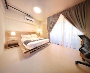 a bedroom with a bed and a large window at Tamarind Suites by BeeStay Management in Cyberjaya