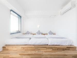 a white bedroom with two beds and a window at Mykonos Resort Miura / Vacation STAY 62208 in Yokosuka