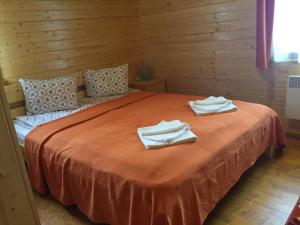 a bedroom with a bed with two towels on it at Nimfa Apartments in Păuleni-Ciuc