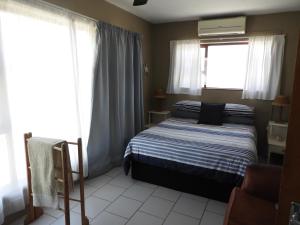a bedroom with a bed and a window at Waterkant 4A in Jeffreys Bay