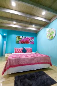 MataveraにあるShineAwayHomes -AC Beachfront RAROTONGAの青い壁のベッドルーム1室(ベッド1台付)