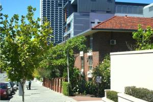 a brick house with a red roof on a city street at M104 West Perth Studio Apartment near Kings Park in Perth