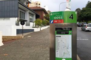 a parking sign on a sidewalk next to a street at M104 West Perth Studio Apartment near Kings Park in Perth