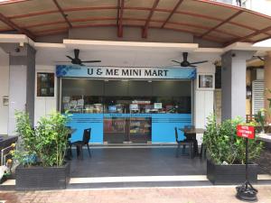 um restaurante do mercado mínimo com mesas e cadeiras em Hotel U and Me em Kulai