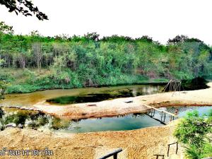 un bassin d'eau au bord d'une rivière dans l'établissement Baan NaraTawan, à Suan Phueng