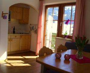 a kitchen with a table and a large window at Landhaus Hirterhütte in Abtenau