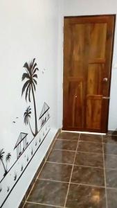 a hallway with a door with palm trees on the wall at Nong Or Blue House Resort in Sukhothai
